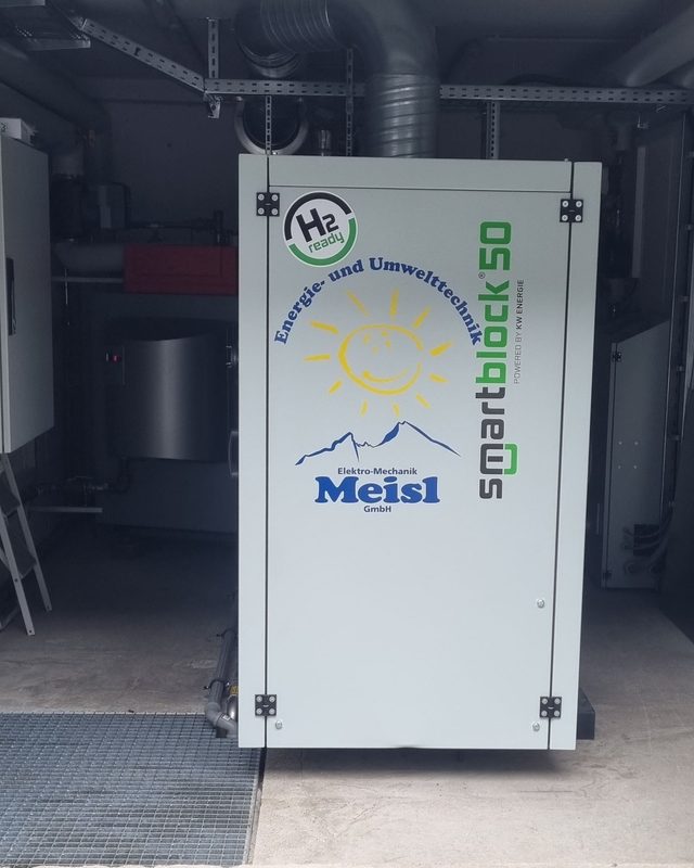 Ein Smartblock-50-Energiespeicher steht in einem Technikraum mit Rohren, Lüftung und Elektroinstallation.