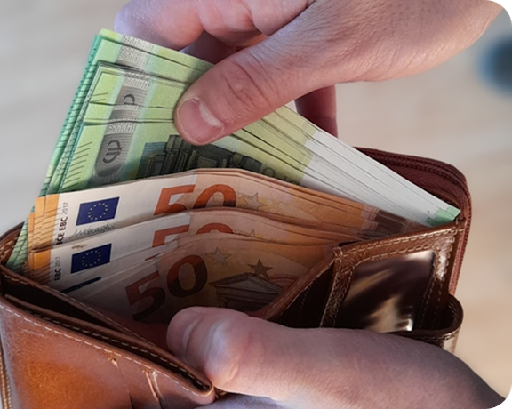 Eine Hand zieht mehrere Euro-Scheine aus einem braunen Lederportemonnaie.