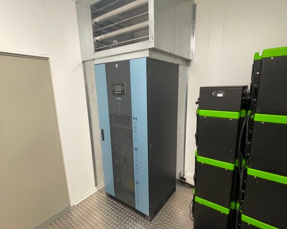 Technikraum mit Batteriespeicher, Lüftungseinheit und modularen Energiespeichermodulen.